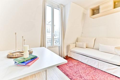 un salon avec un canapé blanc et une table dans l'établissement Studio à 10 minutes de la Basilique du Sacré-Cœur, à Paris