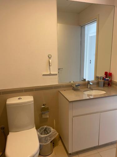 a bathroom with a toilet and a sink and a mirror at Lovely calm 3BR Apt Easy Accessibility to central Dubai with huge balcony and pool view Town Square in Dubai