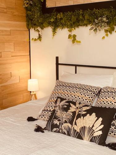 - une chambre avec un lit et une plante sur le mur dans l'établissement Le Gîte du Bonheur avec jacuzzi privatif, à Uriménil