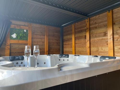 - une baignoire avec deux verres à vin dans l'établissement Le Gîte du Bonheur avec jacuzzi privatif, à Uriménil