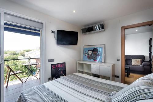a bedroom with a bed and a television and a balcony at Apto en la playa a 20 min en tren de Barcelona in Cabrera de Mar