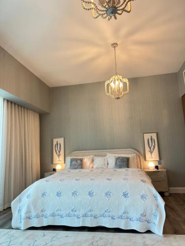 a bedroom with a large bed and a chandelier at Coral Holiday Home in Abu Dhabi