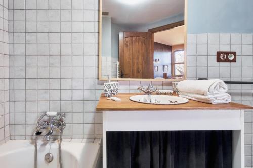 a bathroom with a sink and a tub and a mirror at La Casa De Anta in Asturianos
