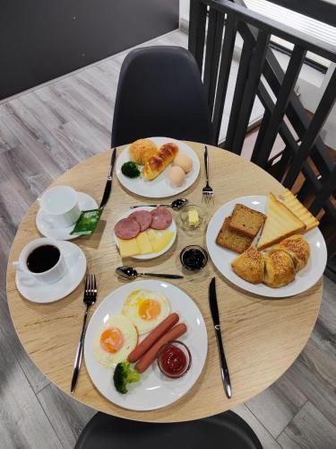 Una mesa de madera con platos de desayuno encima. en The RISE HST, en Tashkent