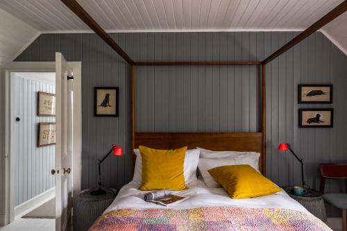 a bedroom with a bed with yellow pillows at Cuttieshillock in Banchory