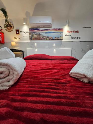 a bedroom with a red bed with a red blanket at Suite SAN GENNARO BIS in Naples