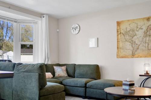 a living room with a green couch and a window at Traveler's Place of Belleville in Belleville