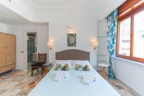 a white bedroom with a large bed with two pillows at "Maiori" Cozy 3 Bedroom, 3 Bathroom House in the Heart of Maiori in Maiori