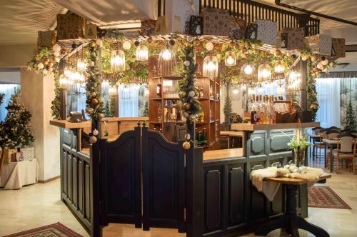 a bar with christmas garland and lights at Hotel Rittinger in Bonyhád