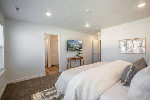 a white bedroom with a bed and a table at Canyon Escape Luxury Ski home American Fork in American Fork