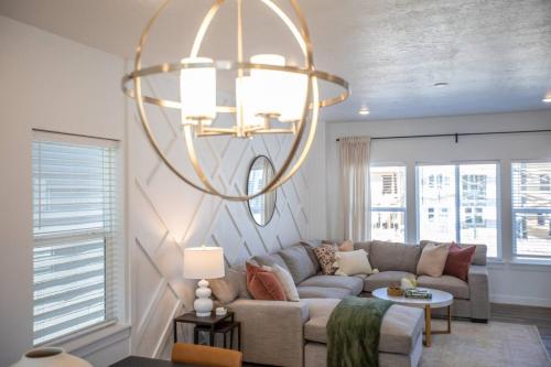 a living room with a couch and a chandelier at Canyon Escape Luxury Ski home American Fork in American Fork