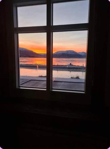 a window with a view of a sunset seen through it at Bryggjan Boutique Hotel in Akureyri