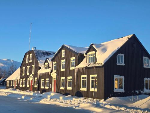 a black building with snow on it at Bryggjan Boutique Hotel in Akureyri