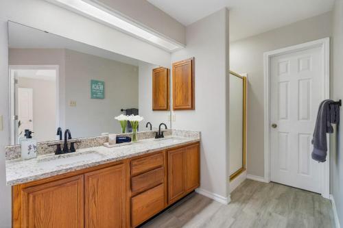 a bathroom with a double sink and a mirror at Blissful Heated Pool Retreat in Corpus Christi