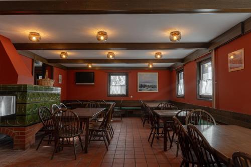 a restaurant with wooden tables and chairs and red walls at Old House - Krvavec ski resort in Cerklje na Gorenjskem
