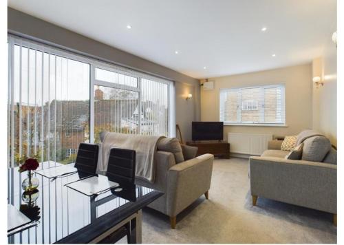 a living room with a couch and a table at Tallets Apartment with Balcony & Parking in Tewkesbury