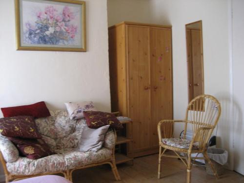 ein Wohnzimmer mit einer Couch und zwei Sesseln in der Unterkunft Cosy character cottage conservation area in St Albans