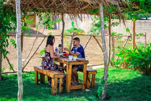 a man and a woman sitting at a table at Mirante dos Ventos in Luis Correia