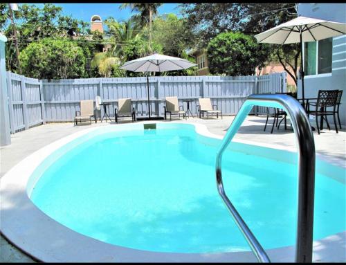 a large swimming pool with chairs and umbrellas at Las Olas 1BR Pool Free Parking Walk to Beach & Restaurants in Fort Lauderdale