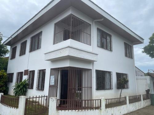 a white building with barred windows at Hostel Casa Mar in Liberia
