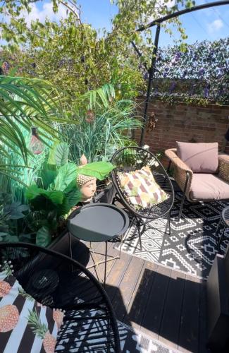 a patio with a table and chairs and plants at Sandy feet retreat in Exmouth