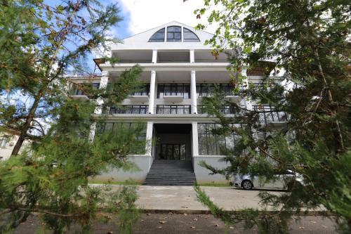 a white building with a staircase in front of it at Green Hotel Tskaltubo in Tskaltubo