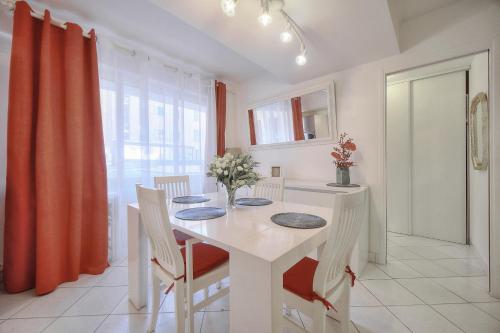 une salle à manger blanche avec une table et des chaises blanches dans l'établissement 2 pieces moderne centre ville A1B237, à Cannes