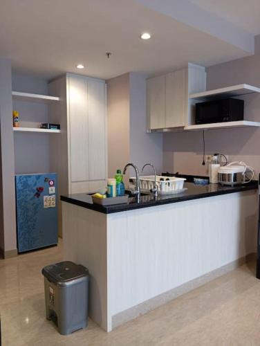 a kitchen with a counter and a trash can at Homey 1 BR Apt at Branz BSD in Tangerang