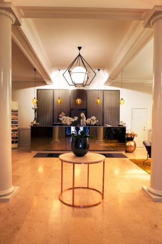 a room with a table with a vase on it at Elite Stora Hotellet Linköping in Linköping