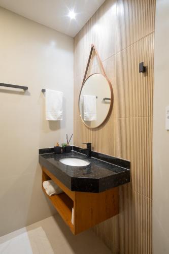 a bathroom with a black sink and a mirror at Pousada Encantare in Aracaju