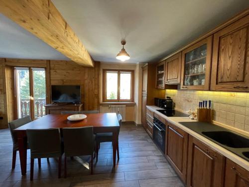 a kitchen with a wooden table and a dining room at Maison Belle Vue in Courmayeur