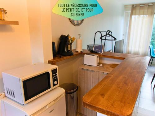 - un four micro-ondes installé au-dessus d'une table dans la cuisine dans l'établissement Le Pic'Vert - FREE Parking - 400m Hospital - 15min Train station & HISTORIC Center - Air conditionner - Calm & Cosy, à Bergerac