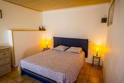 a bedroom with a bed and two lamps on two tables at Gîte Spacieux et Authentique au Coeur de la Nature in Le Poët