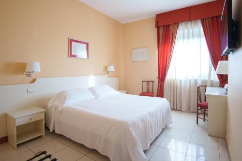 a hotel room with a white bed and a window at Barion Hotel & Congressi in Bari