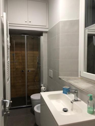a bathroom with a sink and a toilet and a shower at Villa Santa Chiara Lesa - appartamento vista lago con piscina in Lesa