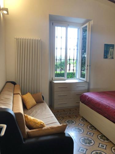 a living room with a couch and a window at Villa Santa Chiara Lesa - appartamento vista lago con piscina in Lesa