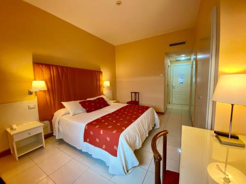 a bedroom with a large bed with a red blanket at Barion Hotel & Congressi in Bari