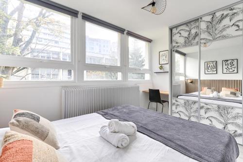 une chambre avec un lit avec des serviettes dessus dans l'établissement Saint Fargeau Gambetta III Lovely Apartment 4P-1BR, à Paris