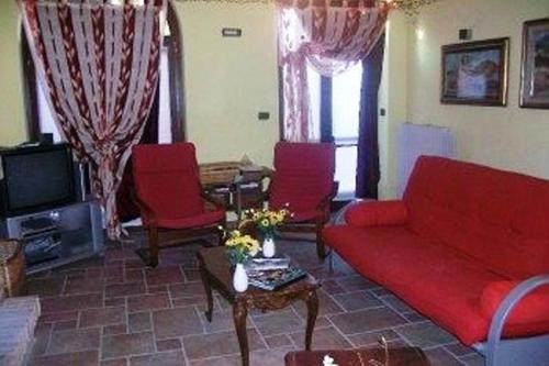 a living room with a red couch and red chairs at Tra... Monti E Vigne in La Morra