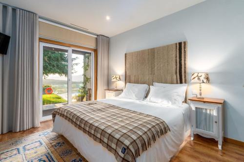 a bedroom with a bed and a large window at Casa Avó Chiquinha in Montalegre