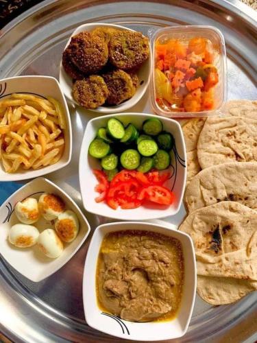 a tray of food with different types of food on it at فندق النخيل in Siwa