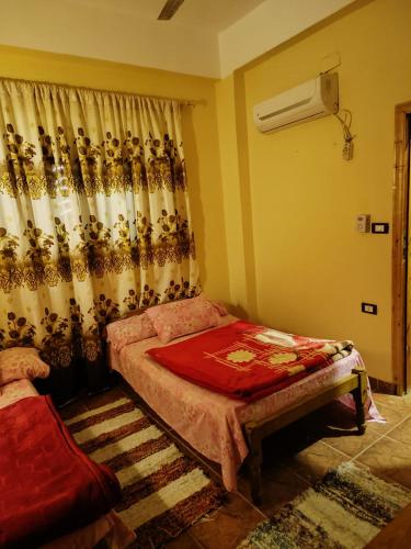 a bedroom with a bed and a window with curtains at فندق النخيل in Siwa
