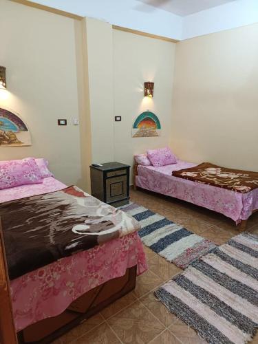two beds in a room with pink sheets at فندق النخيل in Siwa
