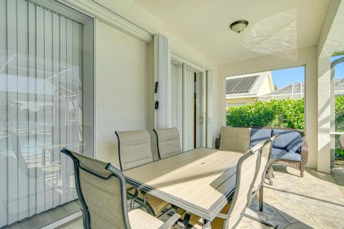 a porch with a wooden table and chairs on a balcony at Sunny Fort Myers Home with Heated Pool! in Fort Myers