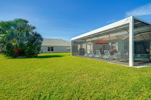 a pavilion with chairs and a lawn in front of a house at Sunny Fort Myers Home with Heated Pool! in Fort Myers