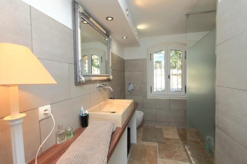 une salle de bain avec un lavabo et un miroir dans l'établissement Villa La Raffinée, au coeur des garrigues du Luberon, à Gordes