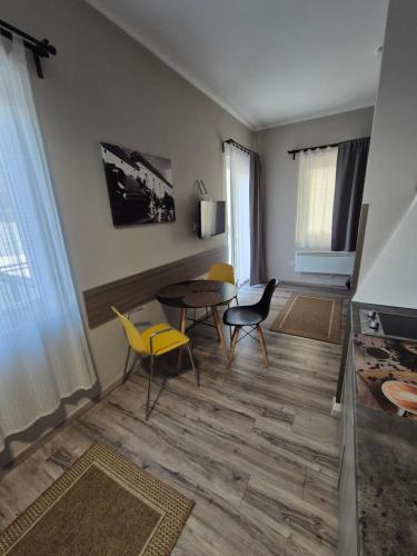 a living room with a table and chairs at Marusius Apartmanház in Makó