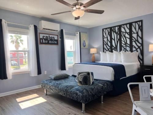 a bedroom with a bed and a bench with a pillow at The Mark at Surfside #7 in Surfside Beach