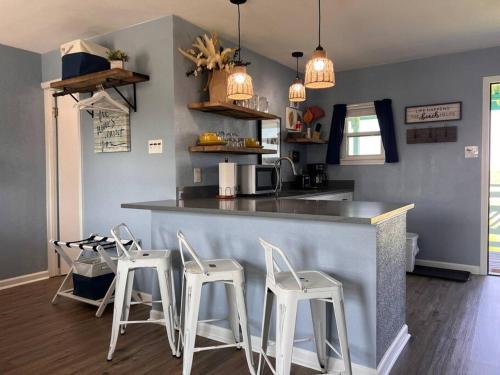 a kitchen with a counter and four stools at The Mark at Surfside #7 in Surfside Beach