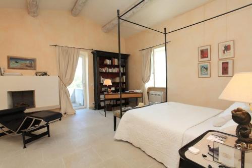 - une chambre avec un lit, une chaise et une cheminée dans l'établissement Villa l'Écrin, piscine et 3 terrasses, à Gordes